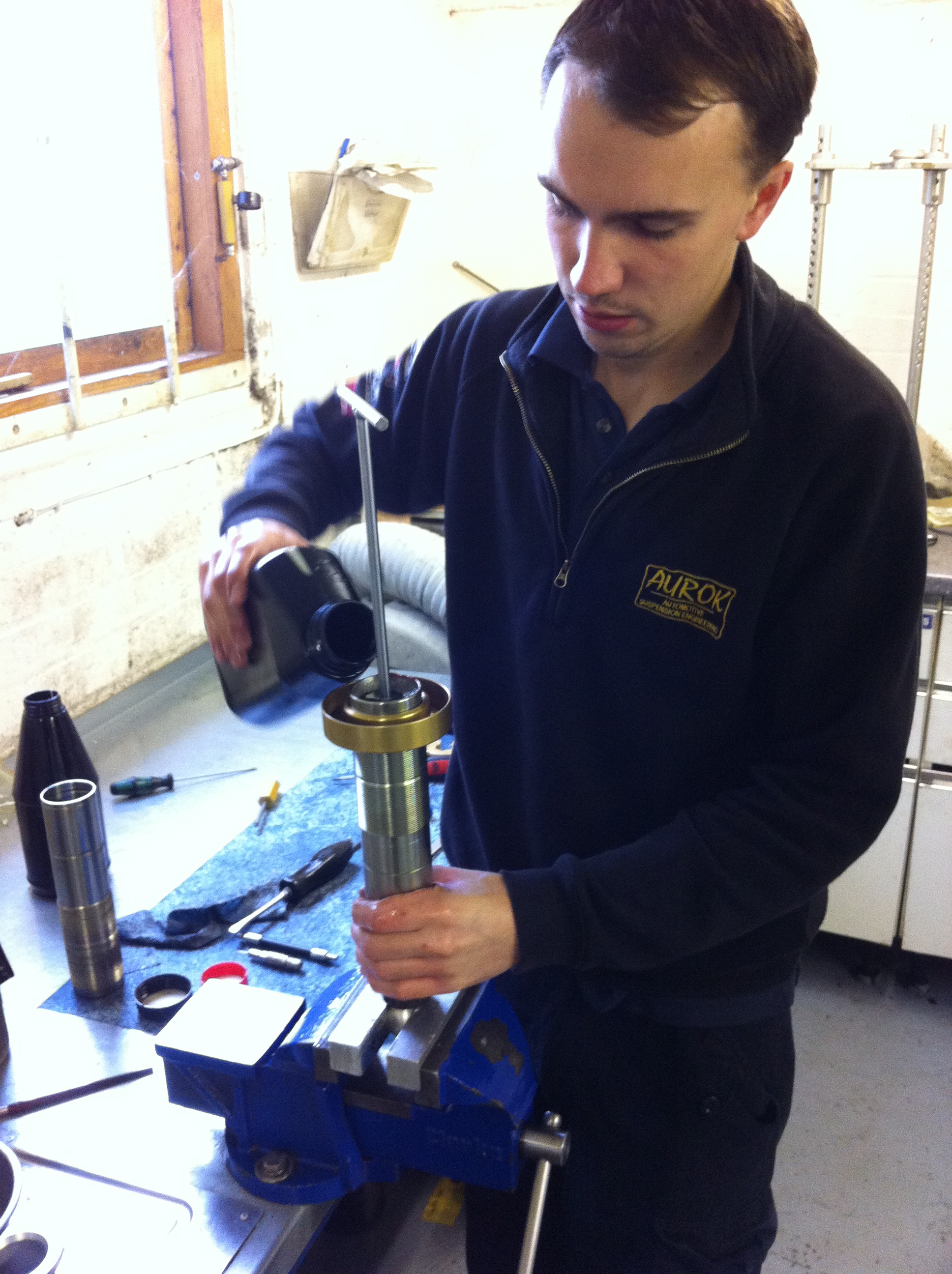 filling the damper with oil, taking care no bubbles remain